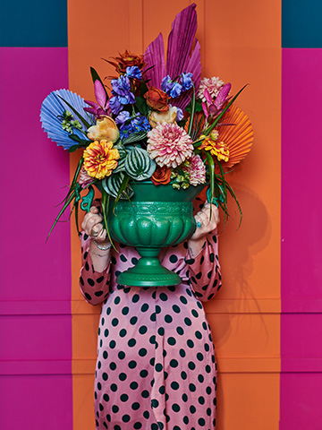 Foto vrouw met bloempot en droogbloemen in haar handen met kleurrijke achtergrond